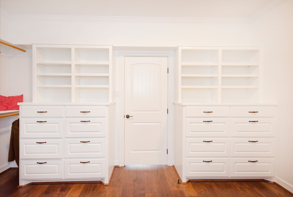 Diseño de armario vestidor unisex tradicional renovado con armarios abiertos, puertas de armario blancas y suelo de madera en tonos medios