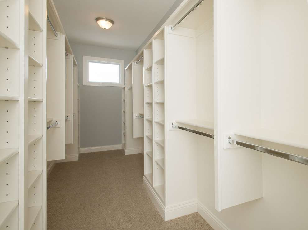 Photo of a medium sized traditional gender neutral walk-in wardrobe in Indianapolis with open cabinets, white cabinets and carpet.