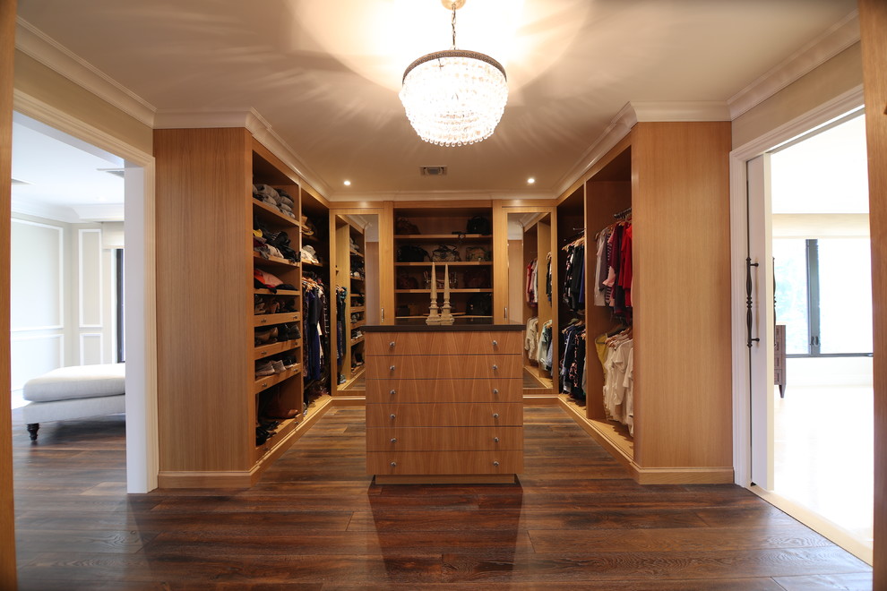 Inspiration for a large transitional gender-neutral dark wood floor and brown floor walk-in closet remodel in Miami with open cabinets and medium tone wood cabinets
