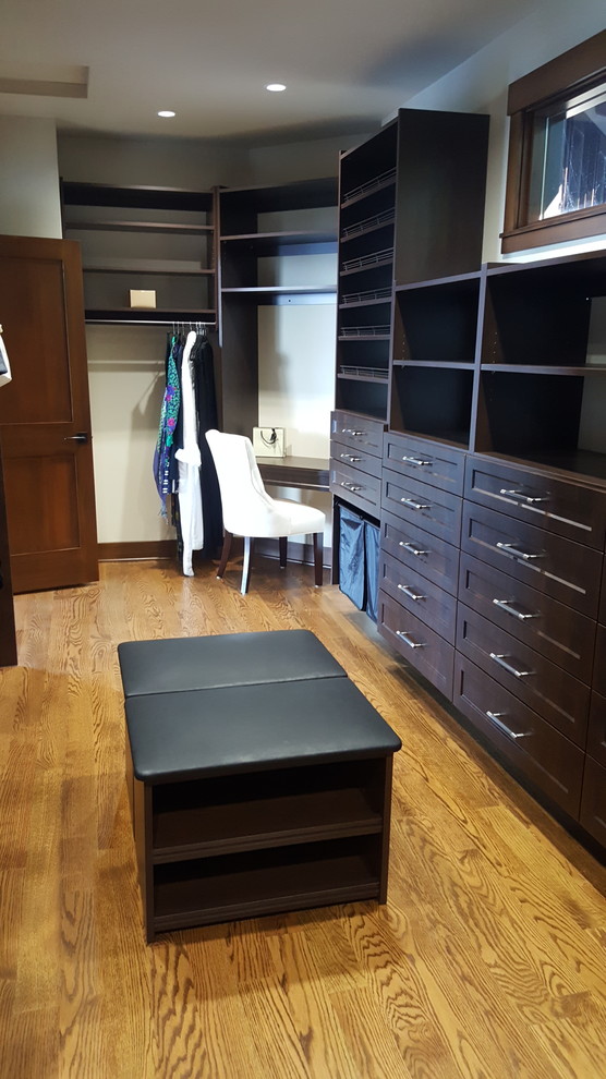 Design ideas for an expansive classic gender neutral walk-in wardrobe in Seattle with shaker cabinets, dark wood cabinets and medium hardwood flooring.
