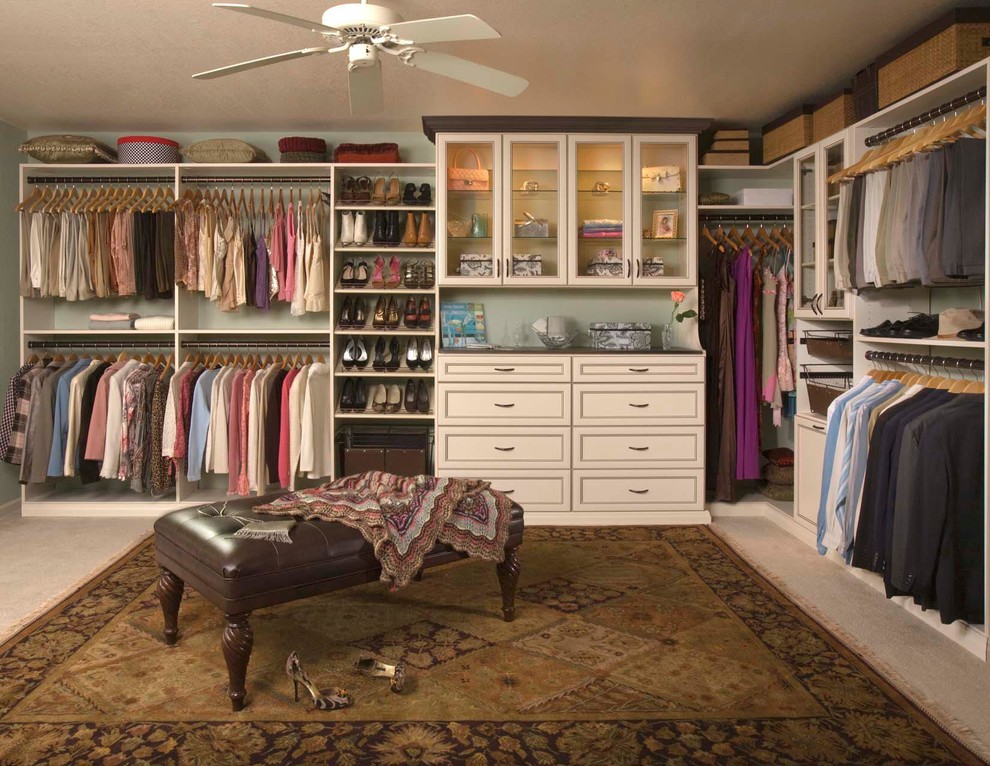 Foto de armario vestidor unisex clásico renovado grande con armarios con paneles con relieve, puertas de armario de madera en tonos medios y moqueta