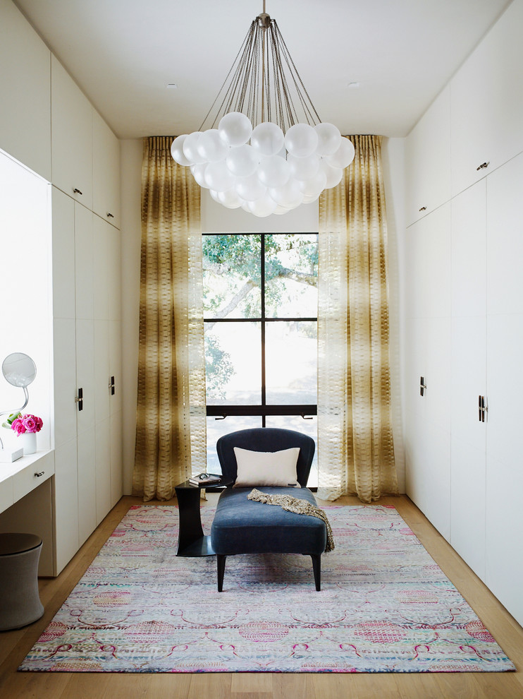 Inspiration for a contemporary dressing room for women in San Francisco with flat-panel cabinets, white cabinets and light hardwood flooring.