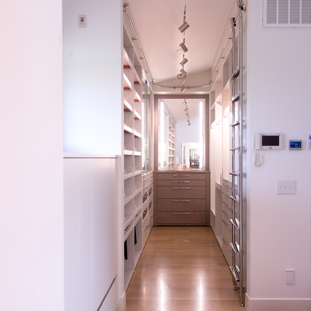 На фото: гардеробная комната среднего размера, унисекс в современном стиле с плоскими фасадами, белыми фасадами, светлым паркетным полом и бежевым полом