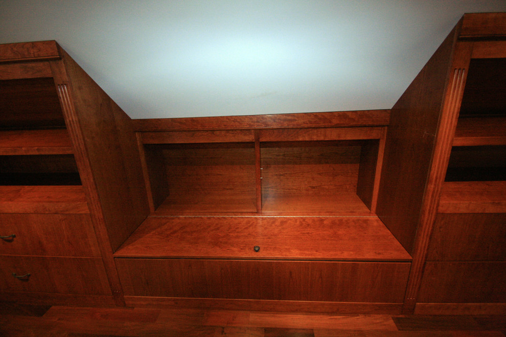 Diseño de armario vestidor unisex tradicional grande con puertas de armario de madera oscura y suelo de madera en tonos medios