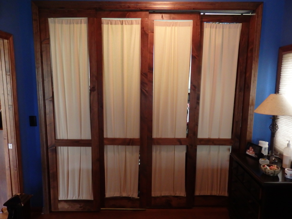 Ejemplo de armario unisex bohemio de tamaño medio con puertas de armario de madera en tonos medios y suelo de madera oscura