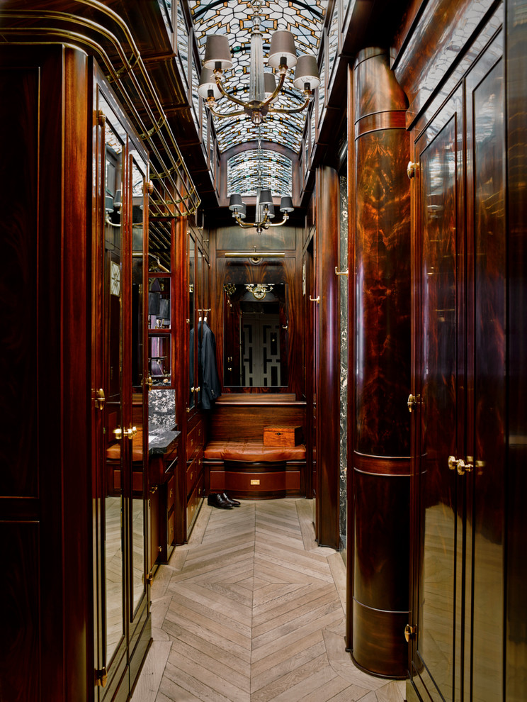 Пример оригинального дизайна: огромная гардеробная комната в классическом стиле с темными деревянными фасадами, светлым паркетным полом и бежевым полом для мужчин