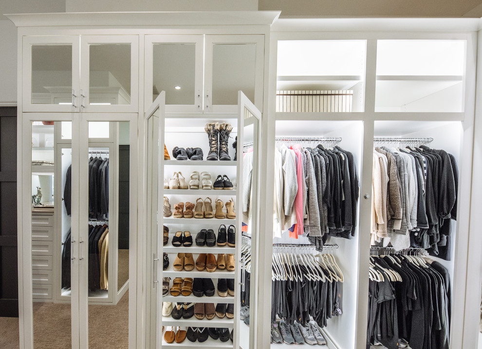 Photo of a large classic gender neutral walk-in wardrobe in Dallas with beaded cabinets, white cabinets, carpet and beige floors.