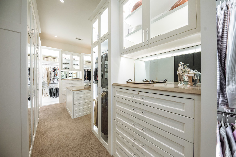 Diseño de armario vestidor unisex tradicional renovado grande con armarios con rebordes decorativos, puertas de armario blancas, moqueta y suelo beige