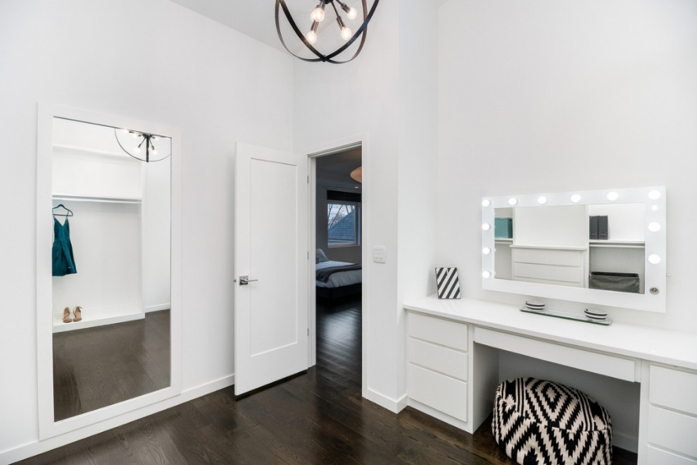 シカゴにある高級な広いモダンスタイルのおしゃれなフィッティングルーム (フラットパネル扉のキャビネット、白いキャビネット、茶色い床、無垢フローリング) の写真