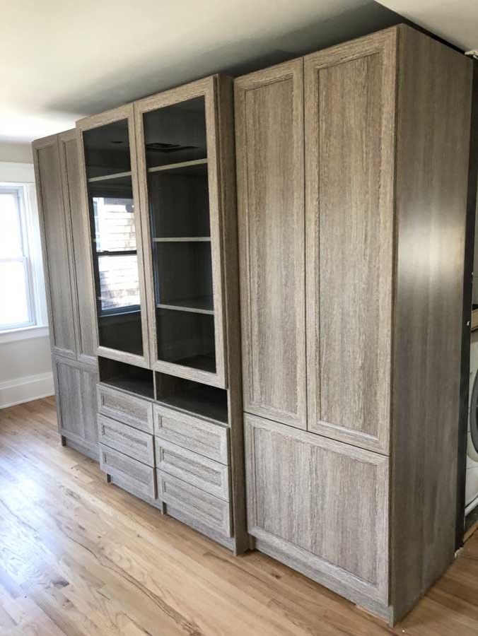 Modelo de armario unisex clásico renovado de tamaño medio con armarios con paneles empotrados, puertas de armario de madera oscura y suelo de madera clara