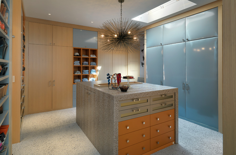 Diseño de armario vestidor unisex moderno con armarios con paneles lisos, puertas de armario de madera clara, moqueta y suelo beige