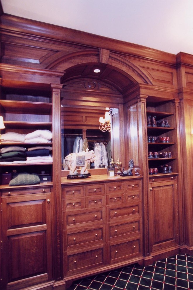 Modelo de vestidor de hombre clásico con armarios con paneles con relieve, puertas de armario de madera oscura y moqueta