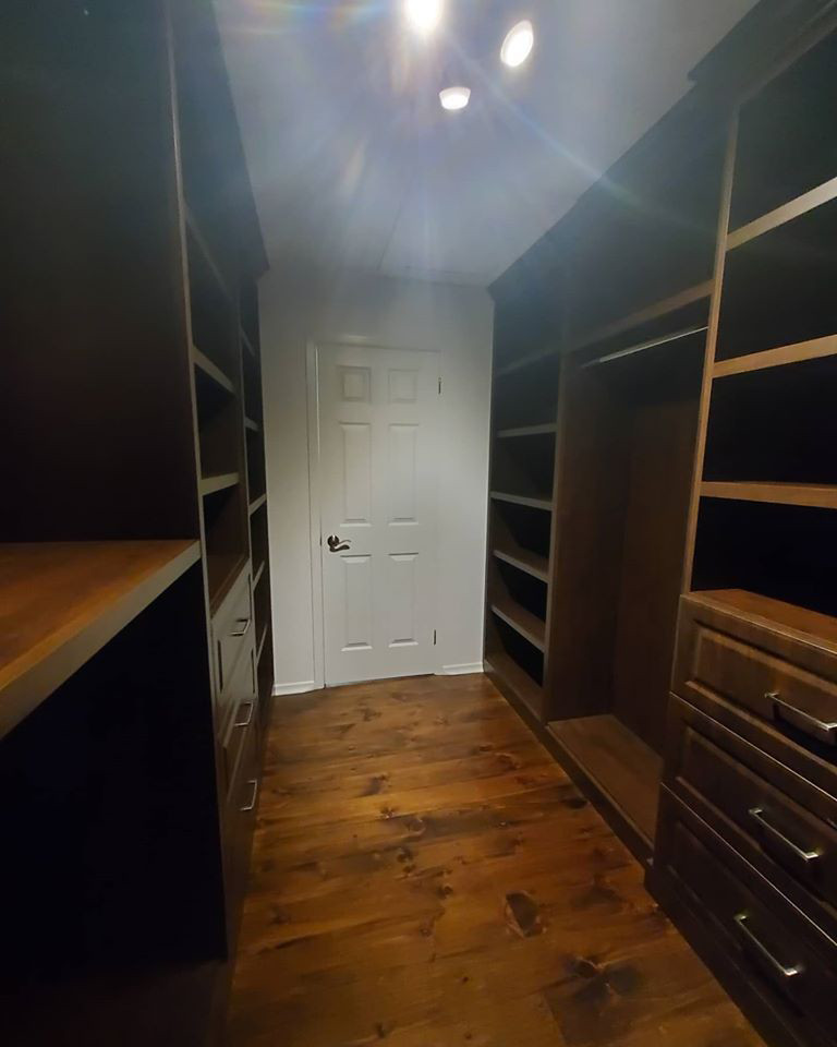 Ejemplo de armario vestidor unisex con armarios con paneles con relieve y puertas de armario marrones