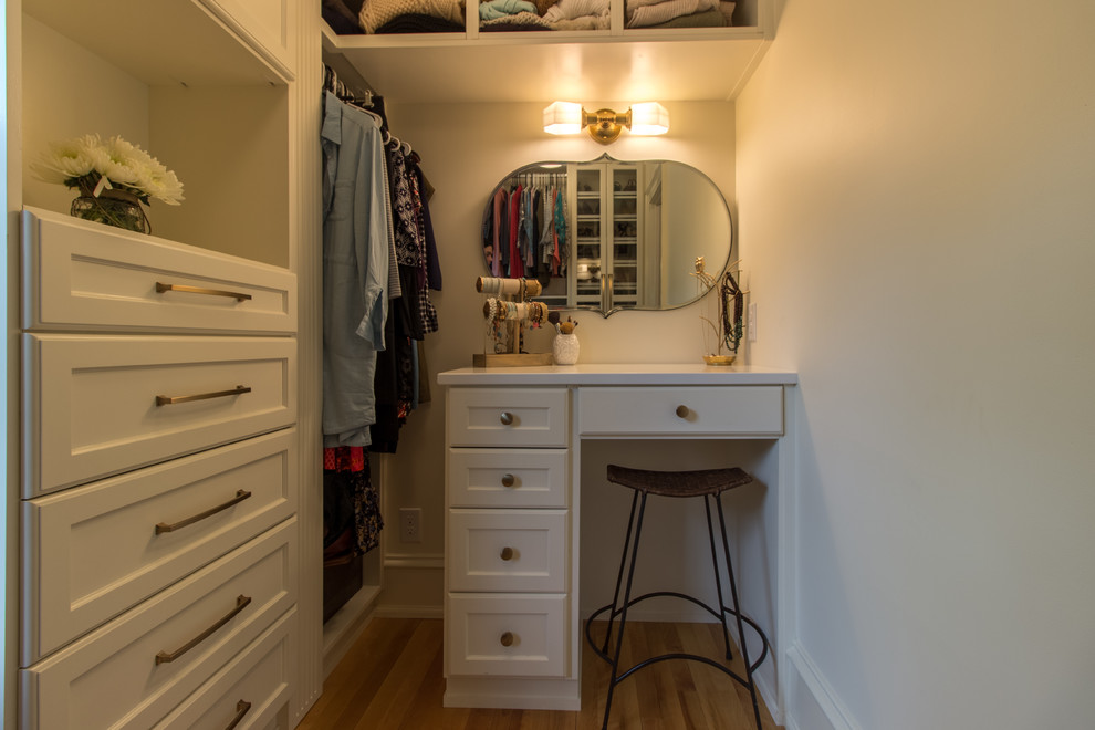 Exempel på ett klassiskt walk-in-closet, med luckor med glaspanel, vita skåp, mellanmörkt trägolv och brunt golv