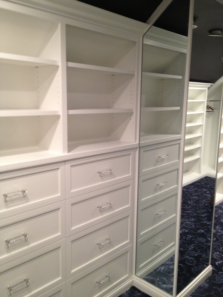 Modelo de armario vestidor de hombre clásico renovado de tamaño medio con armarios con paneles empotrados, puertas de armario blancas, moqueta y suelo azul
