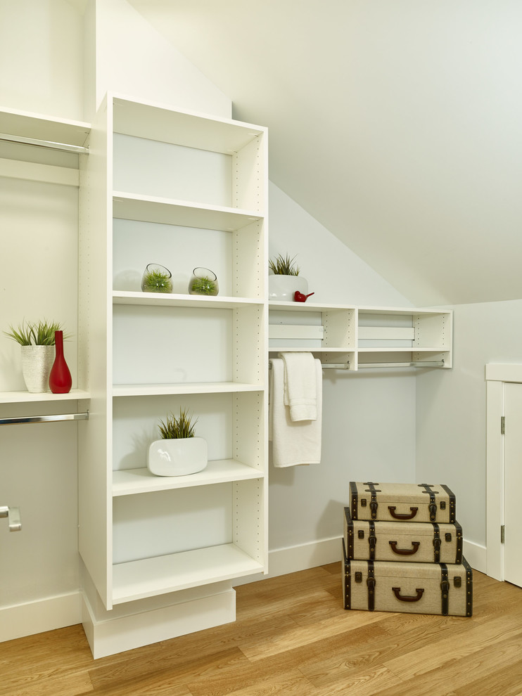Diseño de armario vestidor unisex actual pequeño con armarios abiertos, puertas de armario blancas y suelo de madera clara