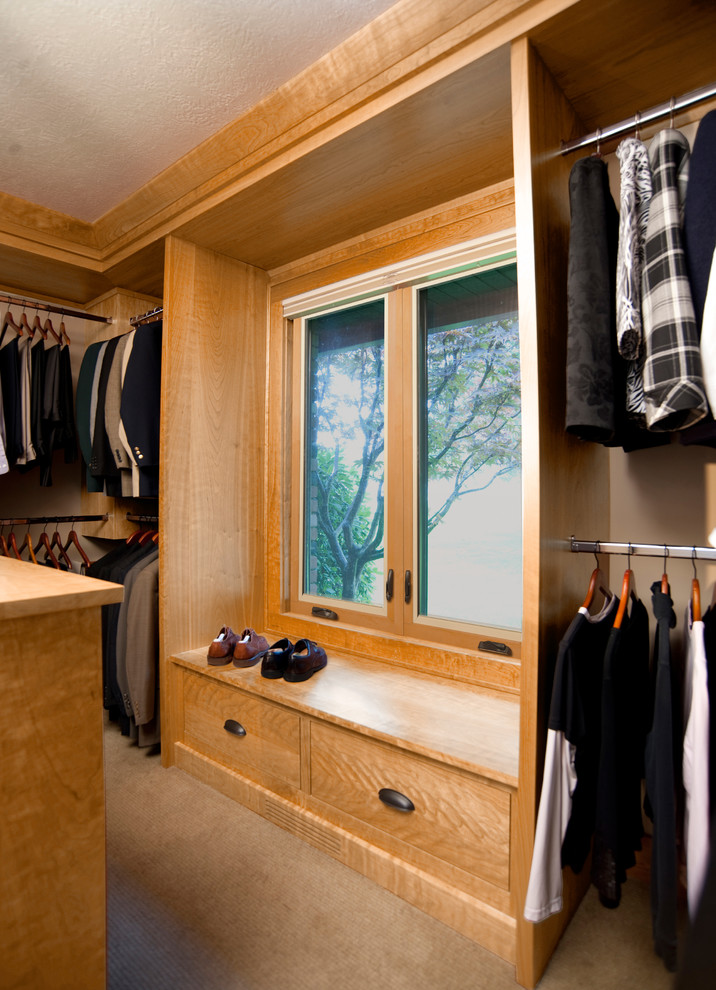 Ejemplo de armario vestidor unisex contemporáneo grande con armarios con paneles lisos, puertas de armario de madera clara, moqueta y suelo beige