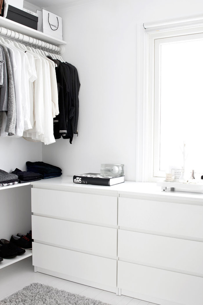 This is an example of a small modern gender neutral standard wardrobe in Madrid with flat-panel cabinets, white cabinets and white floors.