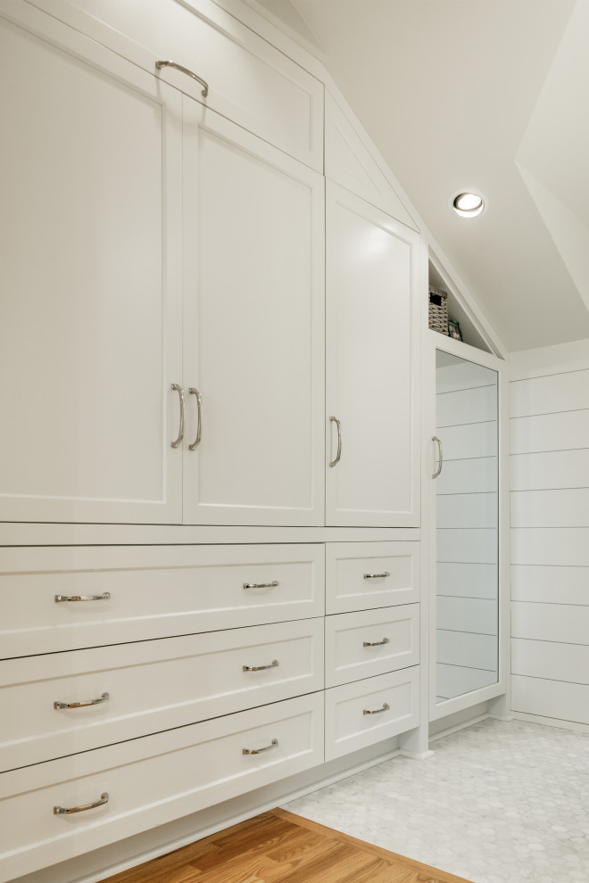 Imagen de armario y vestidor abovedado costero de tamaño medio con a medida, armarios estilo shaker, puertas de armario blancas y suelo de madera en tonos medios