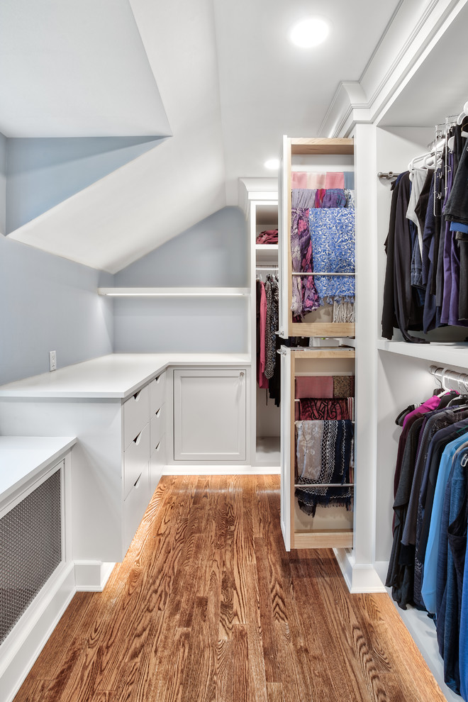 Inspiration for an expansive classic walk-in wardrobe for women in New York with beaded cabinets, white cabinets and medium hardwood flooring.