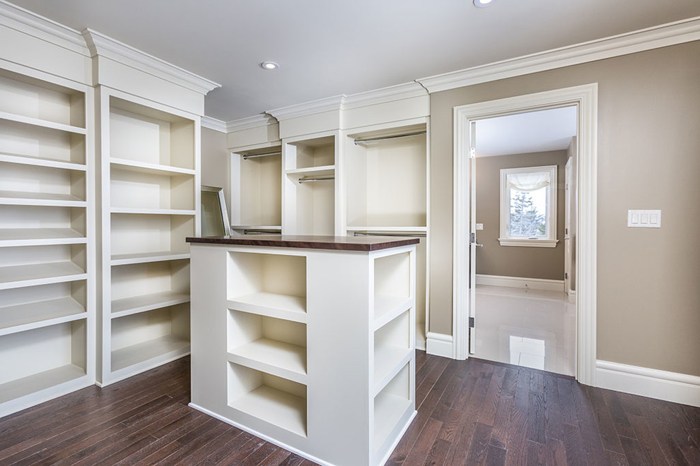 Walk-in closet - mid-sized traditional gender-neutral dark wood floor and brown floor walk-in closet idea in Other with open cabinets and white cabinets