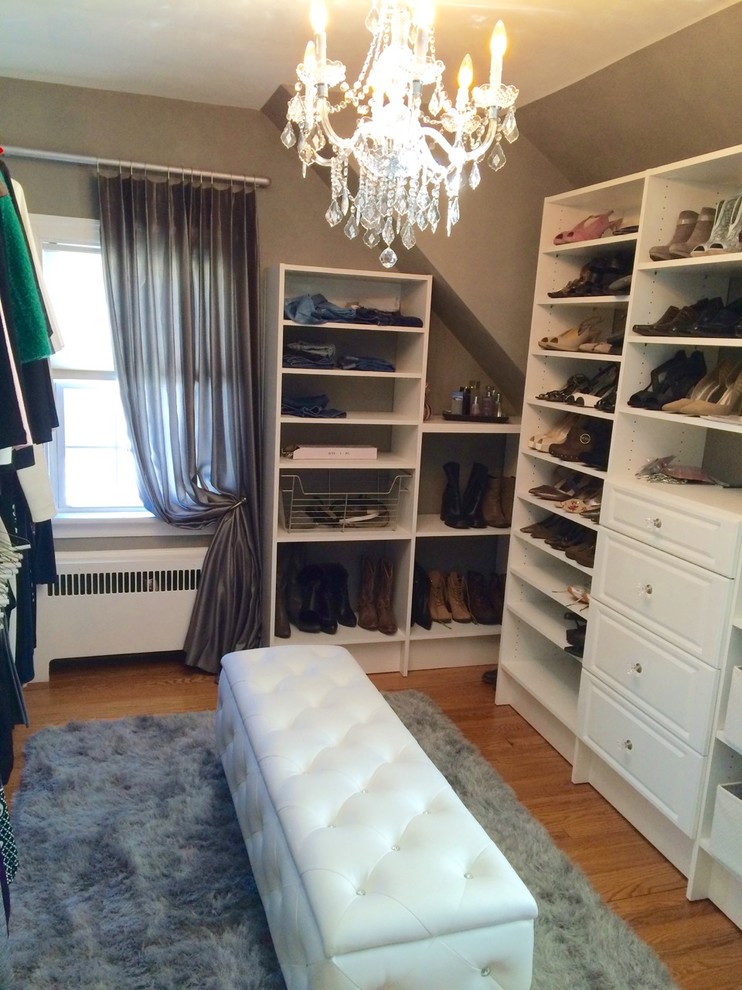 Inspiration for a mid-sized transitional women's light wood floor walk-in closet remodel in New York with raised-panel cabinets and white cabinets