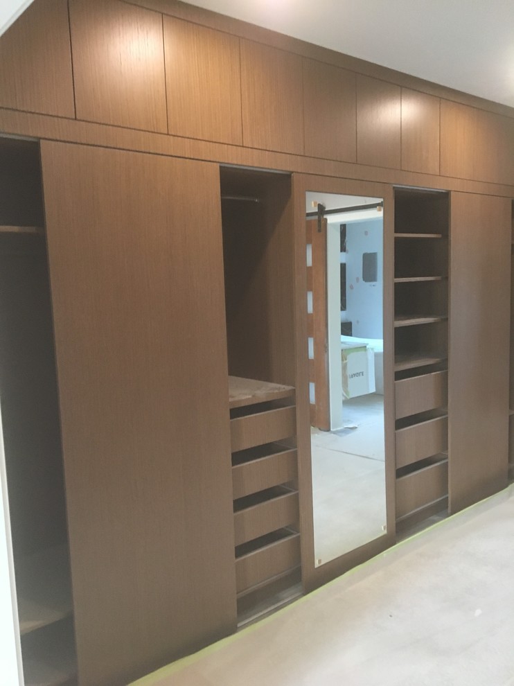 Foto de armario vestidor unisex moderno grande con armarios con paneles lisos y puertas de armario de madera oscura