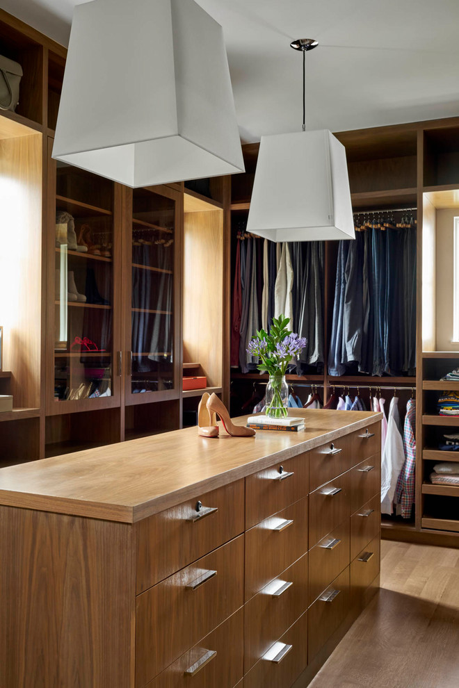 Idée de décoration pour un dressing room tradition en bois brun neutre avec parquet clair.