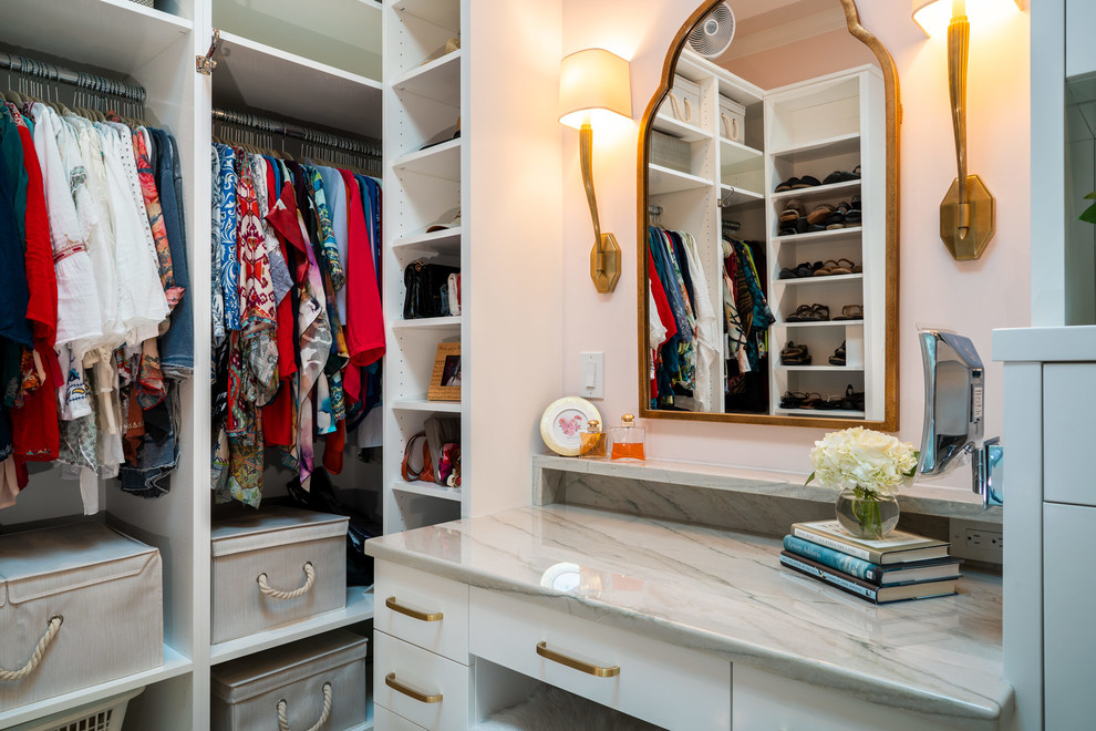 Photo of a classic dressing room for women in Austin with flat-panel cabinets and white cabinets.