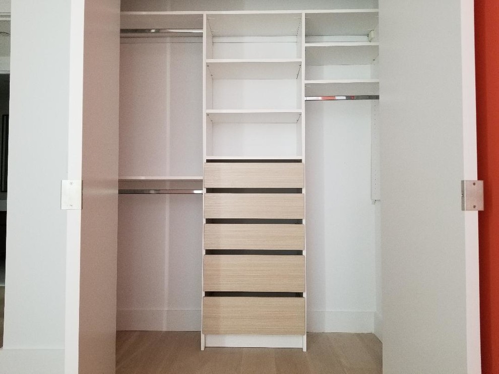 Imagen de armario unisex minimalista de tamaño medio con armarios con paneles lisos, puertas de armario de madera clara, suelo de madera en tonos medios y suelo beige