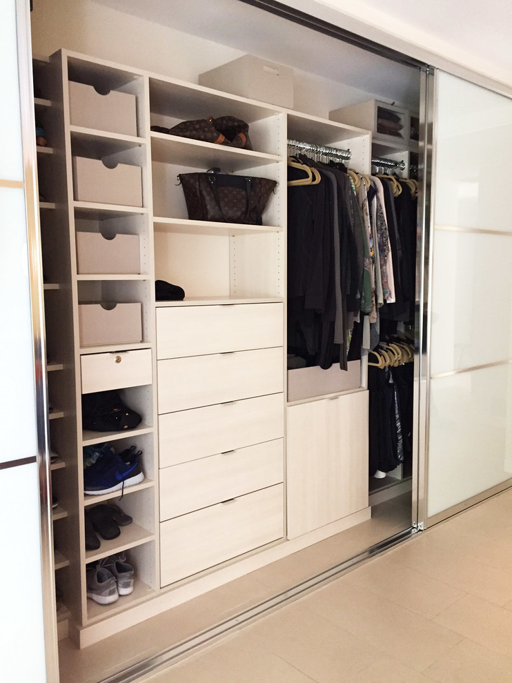 Imagen de armario de tamaño medio con armarios con paneles lisos, puertas de armario de madera clara y suelo de baldosas de cerámica