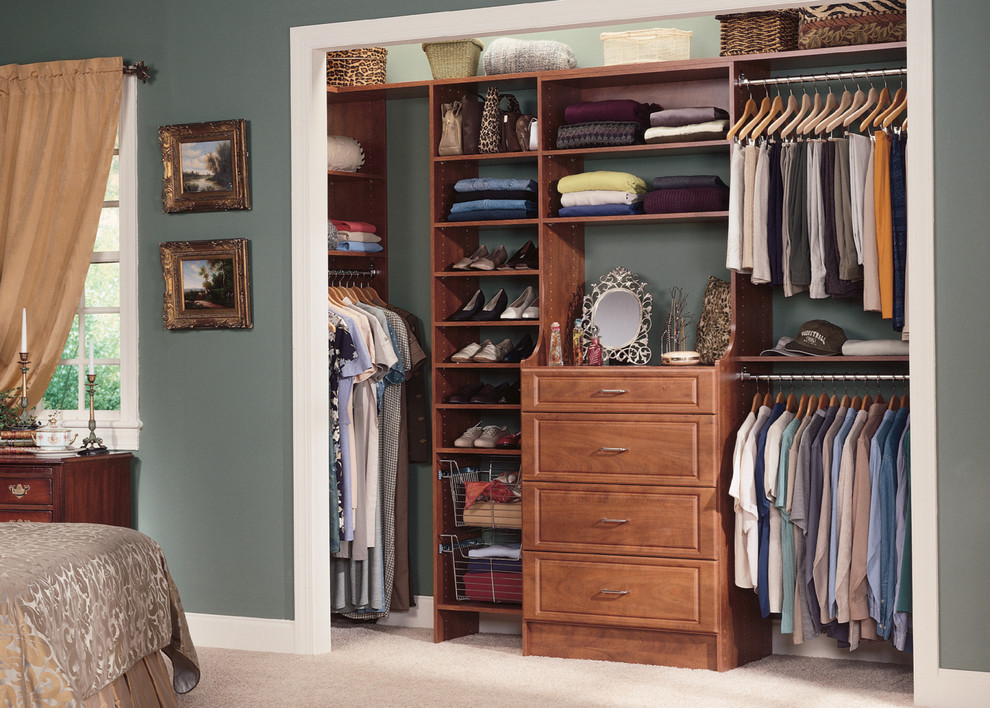 Inspiration for a mid-sized contemporary gender-neutral carpeted reach-in closet remodel in Boston with raised-panel cabinets and medium tone wood cabinets