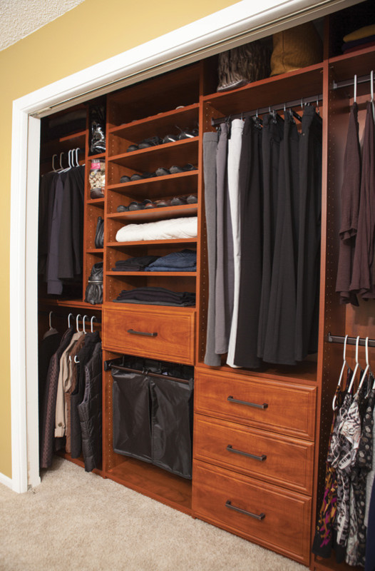 Foto de armario unisex pequeño con armarios con paneles con relieve, puertas de armario de madera oscura, moqueta y suelo gris