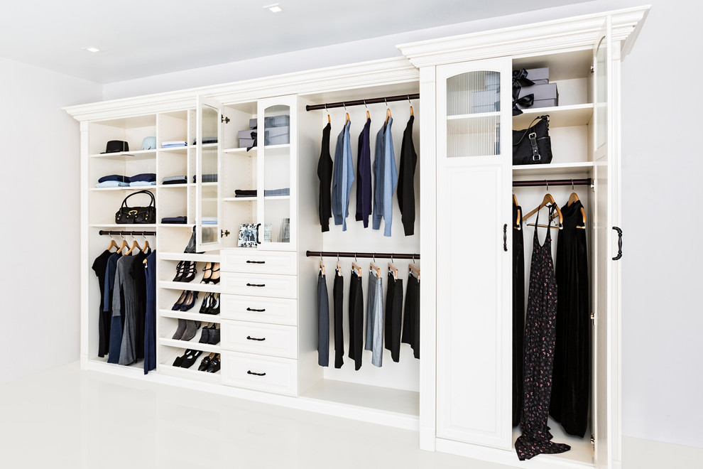 Imagen de armario unisex de tamaño medio con armarios con paneles con relieve, puertas de armario blancas, suelo de baldosas de cerámica y suelo blanco
