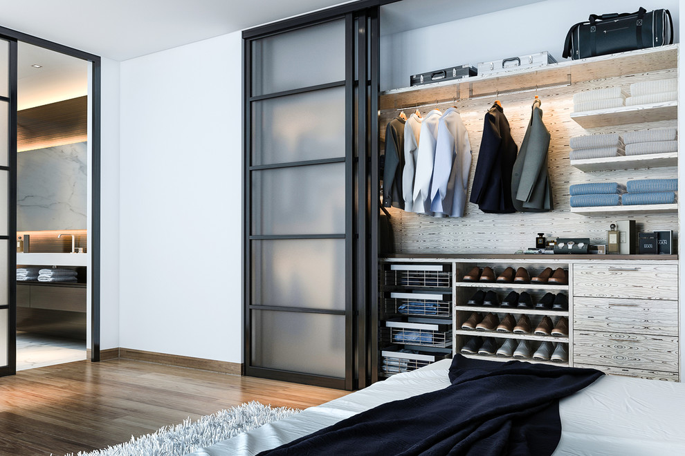 Ejemplo de armario de hombre contemporáneo pequeño con armarios con paneles lisos, puertas de armario grises, suelo de madera en tonos medios y suelo marrón