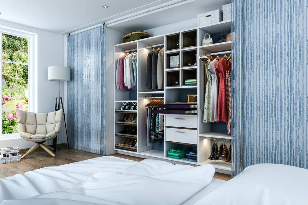 Modelo de armario pequeño con armarios con paneles lisos, puertas de armario blancas, suelo de madera en tonos medios y suelo marrón