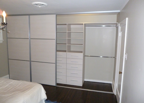 Imagen de armario unisex minimalista de tamaño medio con armarios con paneles lisos y puertas de armario de madera clara