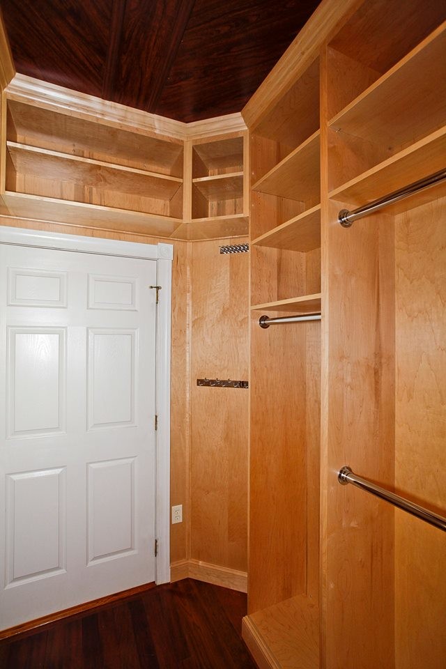 Klassisk inredning av ett mellanstort walk-in-closet för könsneutrala, med öppna hyllor, skåp i ljust trä, mörkt trägolv och brunt golv