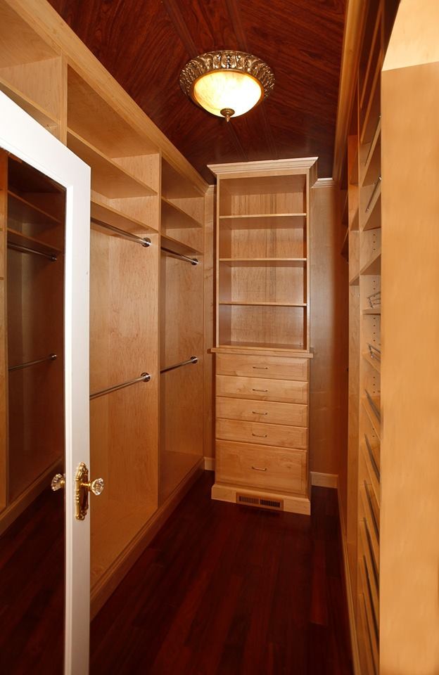 Ispirazione per una cabina armadio unisex chic di medie dimensioni con nessun'anta, ante in legno chiaro, parquet scuro e pavimento marrone