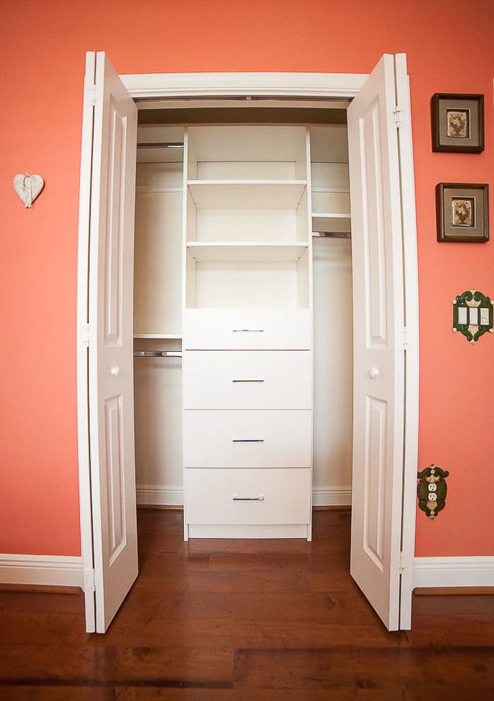 Modelo de armario unisex tradicional renovado pequeño con armarios con paneles lisos, puertas de armario blancas, suelo de madera en tonos medios y suelo marrón