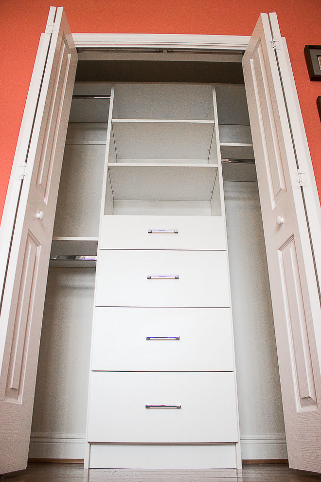 Small classic gender neutral standard wardrobe in Orlando with flat-panel cabinets, white cabinets, medium hardwood flooring and brown floors.