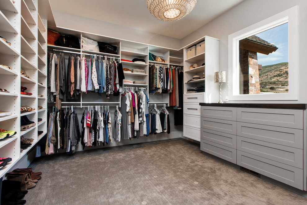 Design ideas for a large contemporary gender neutral dressing room in Salt Lake City with open cabinets, white cabinets and carpet.