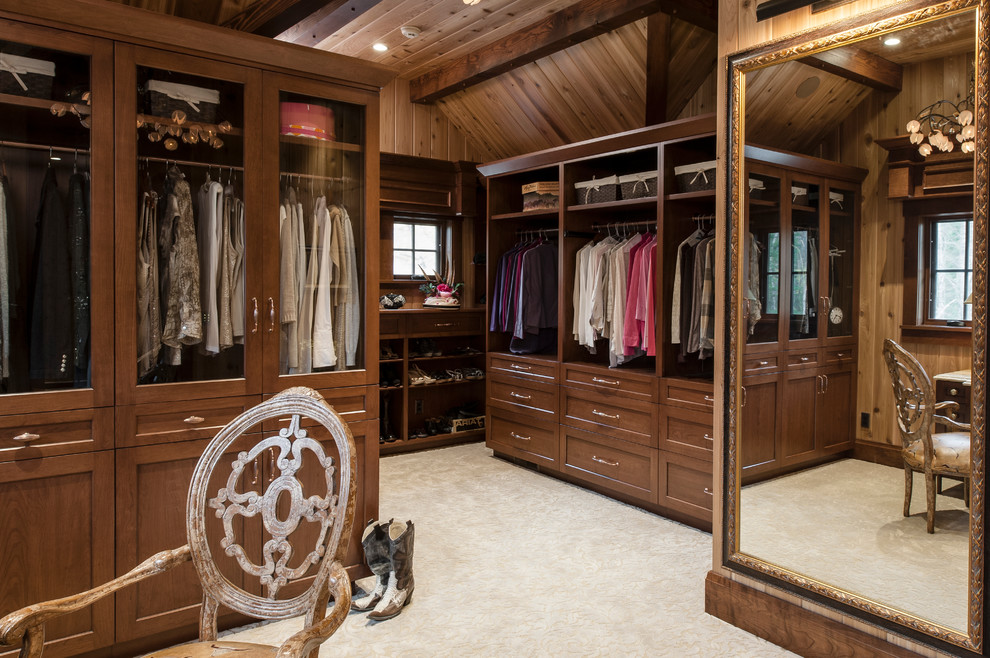 Mid-sized elegant gender-neutral carpeted and beige floor dressing room photo in Other with recessed-panel cabinets and dark wood cabinets