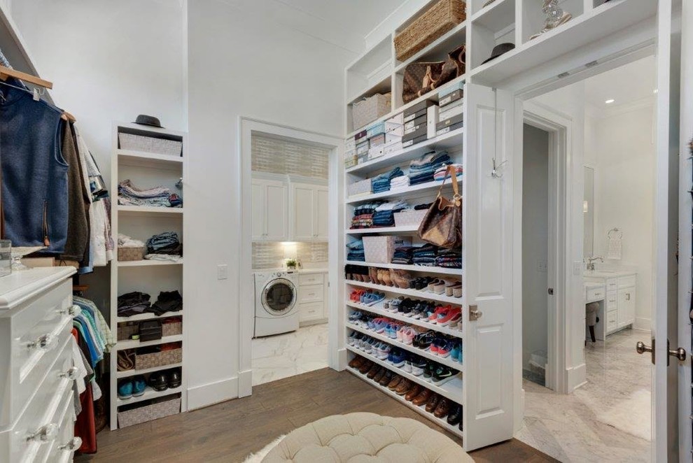 Photo of a large country gender neutral walk-in wardrobe in Miami with open cabinets, white cabinets and medium hardwood flooring.