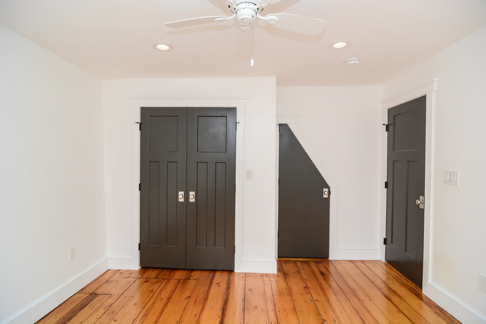 Imagen de armario contemporáneo de tamaño medio con armarios con paneles lisos, puertas de armario grises, suelo de madera clara y suelo marrón