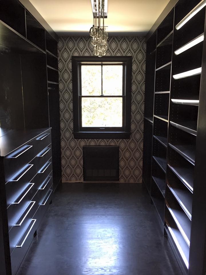 Mid-sized trendy gender-neutral dark wood floor walk-in closet photo in New York with open cabinets and dark wood cabinets