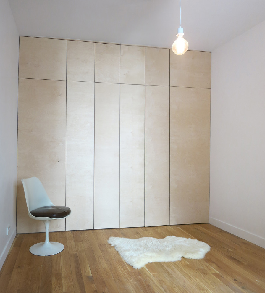 Cette photo montre un grand dressing room moderne en bois clair neutre avec un sol en bois brun.