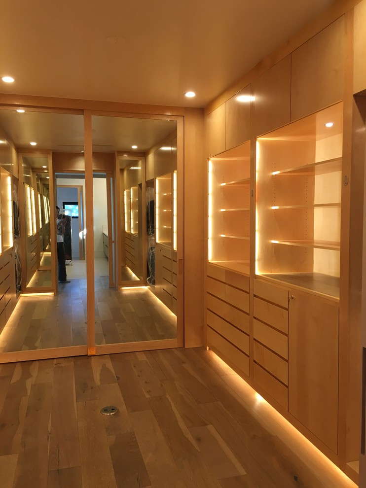 Ejemplo de armario vestidor unisex contemporáneo extra grande con armarios con paneles lisos, puertas de armario de madera clara y suelo de madera clara