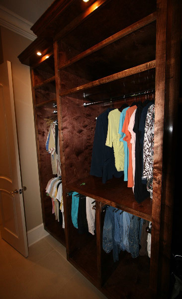 Ejemplo de armario vestidor de hombre clásico de tamaño medio con armarios con paneles con relieve, puertas de armario de madera oscura y suelo de baldosas de porcelana