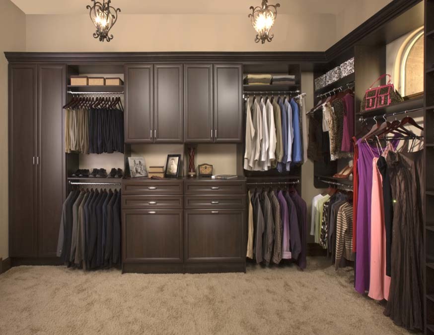 Foto de armario vestidor unisex tradicional de tamaño medio con armarios con paneles con relieve, puertas de armario de madera en tonos medios y moqueta